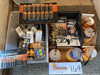 Photo of assorted batteries packaged and loose including Duracell and Energizer with five yellow safety flashing lights packed in boxes