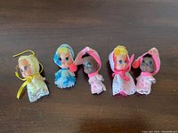 All five Kiddle Klone baby dolls laid out in a row showing their original outfits and different skin tones and hair colors.