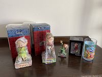Wide shot of all items including boxed Dopey and Grumpy figurines, two small Grumpy figures, and plastic Snow White glass.