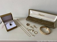 Overall assortment on table including boxed pendant, Mappins bracelet, rings, chains, earrings and pendants.