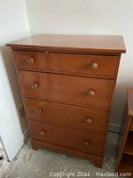 Full front view of the solid Rock Maple tallboy dresser showing five drawers with round wooden knobs and wood finish.