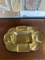 Top view of the vintage brass flower-shaped tray showing the scalloped petal design and rectangular center.