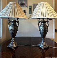 Pair of ornate vintage Dacota table lamps with pleated shades on wooden table