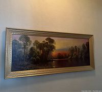 Photo of the landscape painting showing the entire artwork and frame from the front, highlighting its rectangular horizontal format and the framed edges.
