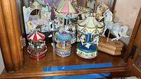 Five carousel figurines grouped together showing varied colors and styles.