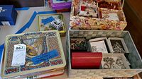 Overview of decorative tins and fabric organizer with assorted jewelry boxed and loose