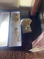 Overview showing ring in box, hoop earrings and chain with locket