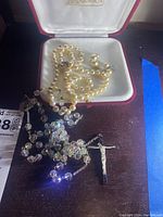 Lot items shown: pearl necklace with sterling clasp, two pairs of pearl earrings, vintage aurora borealis rosary with sterling silver cross.