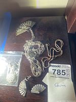 Fan brooch, matching earrings, two necklaces and loose chain displayed together