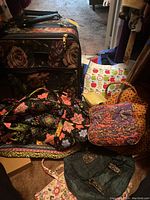 Soft side suitcase with tapestry large floral pattern, duffel bags in quilted floral fabric, and several assorted totes including a denim and printed nylon tote bag.