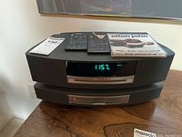 Full view of Bose Wave system atop 3-disc changer module with two remotes and Elton John CD