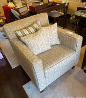 Front angle view of arm chair with cushions arranged on seat