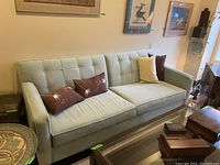 Front view of couch with tufted back and decorative pillows