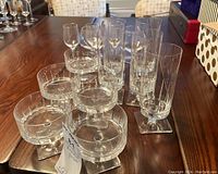 Multiple types of Rosenthal clear glassware including compote cups, aperitif, water, and snifter glasses on wooden table