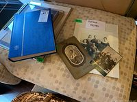 Blue hardcover stamp album with label 'stamps and vintage photos', three vintage photos laid out separately on a beige patterned surface.