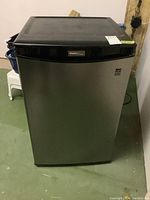 Front view of the Danby brand bar fridge showing stainless steel door and black top panel.