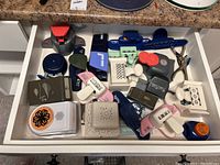 Top-down view of open drawer with about 20 assorted paper crafting punches in various sizes and designs.