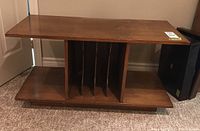 Front view of the wood Mid-Century Modern stereo stand showing the top surface and record storage dividers.