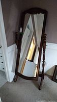 Full view of chevalier style mirror with wooden frame and turned wooden posts.