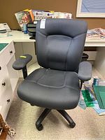 Front view of black upholstered office chair with armrests and caster wheels, showing seat and backrest detail.