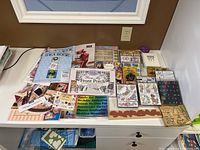 Overall assortment of rubber and foam stamp sets, books, catalogs, and loose stamps arranged on a table.
