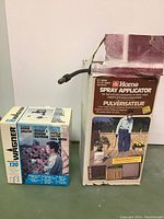 Photo of both boxed items: Wagner Model 120 power sprayer and Homelite spray applicator side by side on floor.