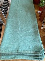 Full view of folded green/blue wool blanket