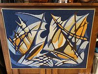 Full front view of framed needlepoint hung on a wall