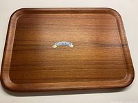 Top side of the teak tray showing warm teak wood with subtle grain and rounded edges.