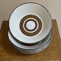 Top view of stacked set of four bowls showing cream color with chocolate speckles and cinnamon circular pattern inside.