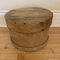 Full view of the round wooden butter box showing the lid and cylindrical shape.