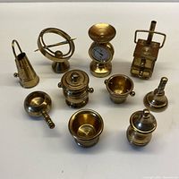 Full view of 10 vintage miniature brass items arranged on a flat surface.