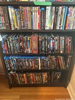 Four-shelf dark wood unit filled with DVDs and VHS
