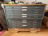 Front view of two stacked gray steel 5-drawer cabinets on wood base