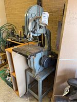 Front view of saw on stand showing table top, blade guard and fence