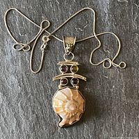 Full view of the necklace and pendant showing the silver box chain and the pendant with shell and four cabochon stones.