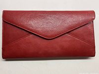 Front view of the vintage leather clutch wallet showing envelope style flap and smooth textured burnt red leather.