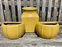 Three planters displayed on a wooden bench outdoor with natural light, showing the overall lot contents.