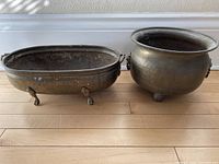 Both solid brass pots side by side showing size difference and overall condition