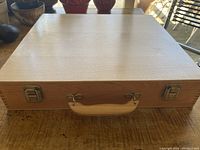 Top view of closed wooden box showing light wood grain surface and edge.