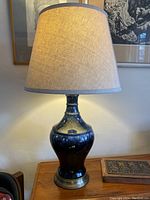 Full lamp with shade illuminated on wooden surface