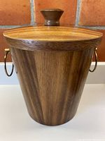 Full frontal view of the teak ice bucket with lid on, showing the wood grain and lid knob