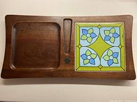 Top view of the whole cheeseboard showing the wood and the tiled floral pattern.