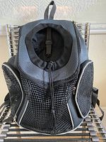 Front view of black mesh pet carrier backpack with large mesh ventilation panel and zipper for entry.