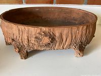 Front angled photo showing the oval shape and textured clay feet and sides of the bonsai pot