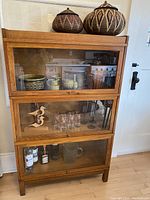 Front view showing all three compartments with decorative barware inside