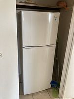 Closed view of white Magic Chef refrigerator and freezer unit in a small space.