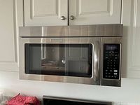 Front view of stainless steel KitchenAid over-the-range microwave installed above stove
