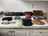All 11 vintage purses arranged on a white kitchen counter surface to show variety in color, material, and style.