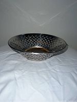 Front view of circular perforated stainless steel bowl with visible wear and tarnish inside